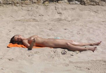 Luxurious youthful woman bare on the beach
