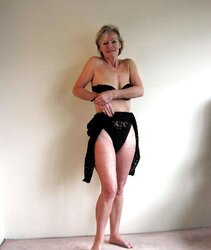 Justine a mature blondie posing in a ebony bondage suit