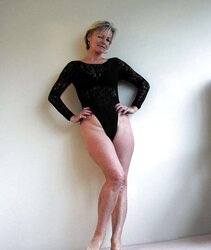 Justine a mature blondie posing in a ebony bondage suit