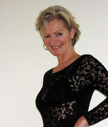Justine a mature blondie posing in a ebony bondage suit