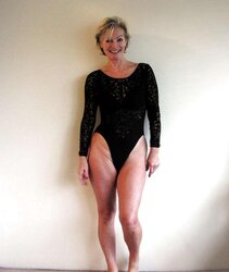 Justine a mature blondie posing in a ebony bondage suit