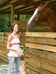 Super Hot brunett unclothes next to her pony