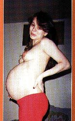 Pregnant black-haired posing her nice tummy